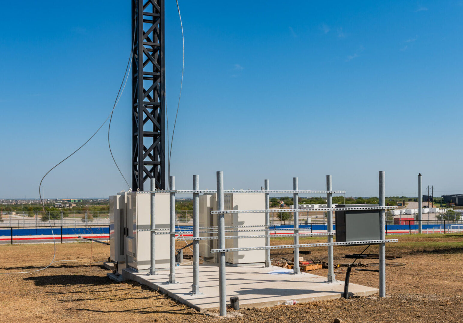 Construction site with concrete blocks and metal scaffolding under a clear blue sky.