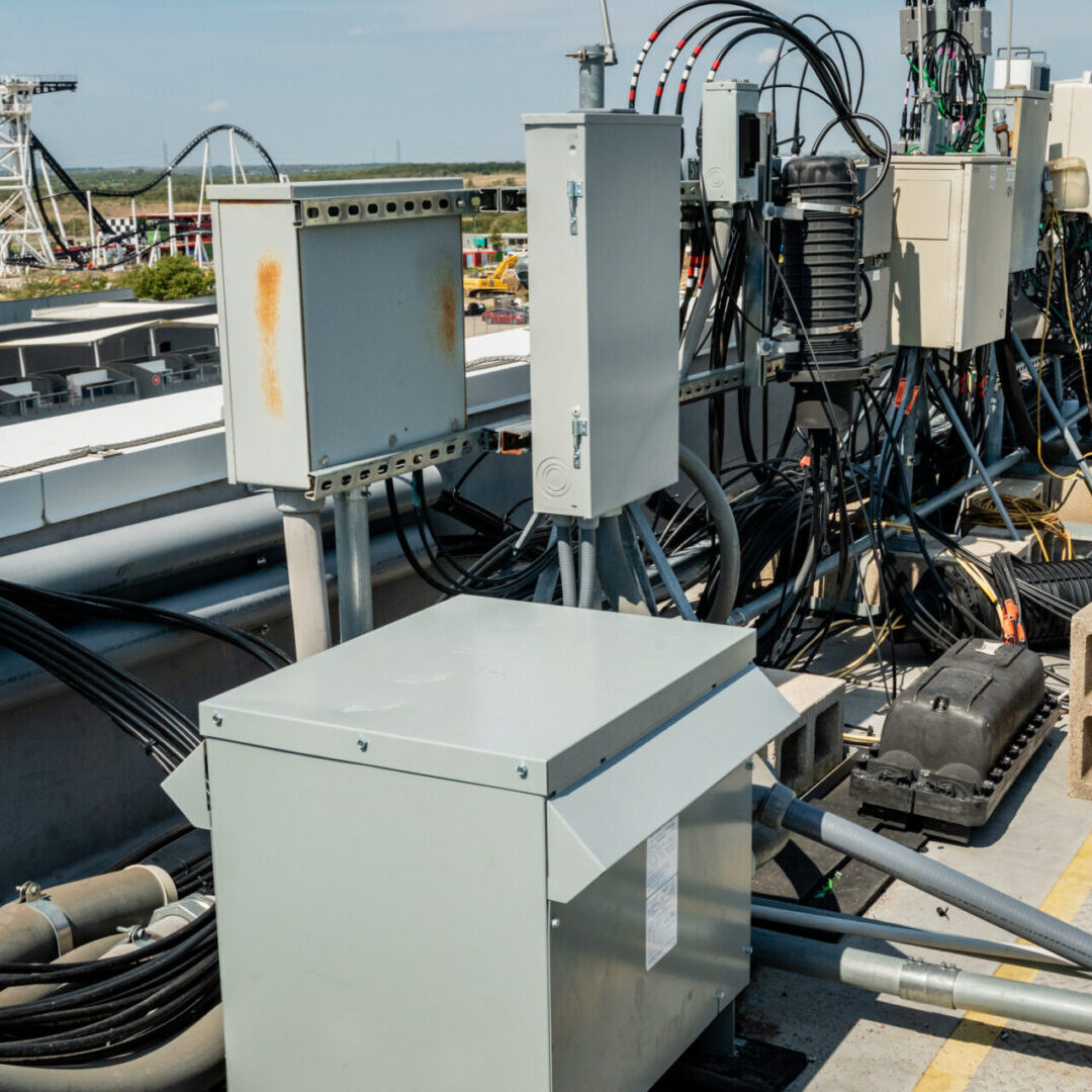 Electrical equipment setup with control panels and cables outdoors.