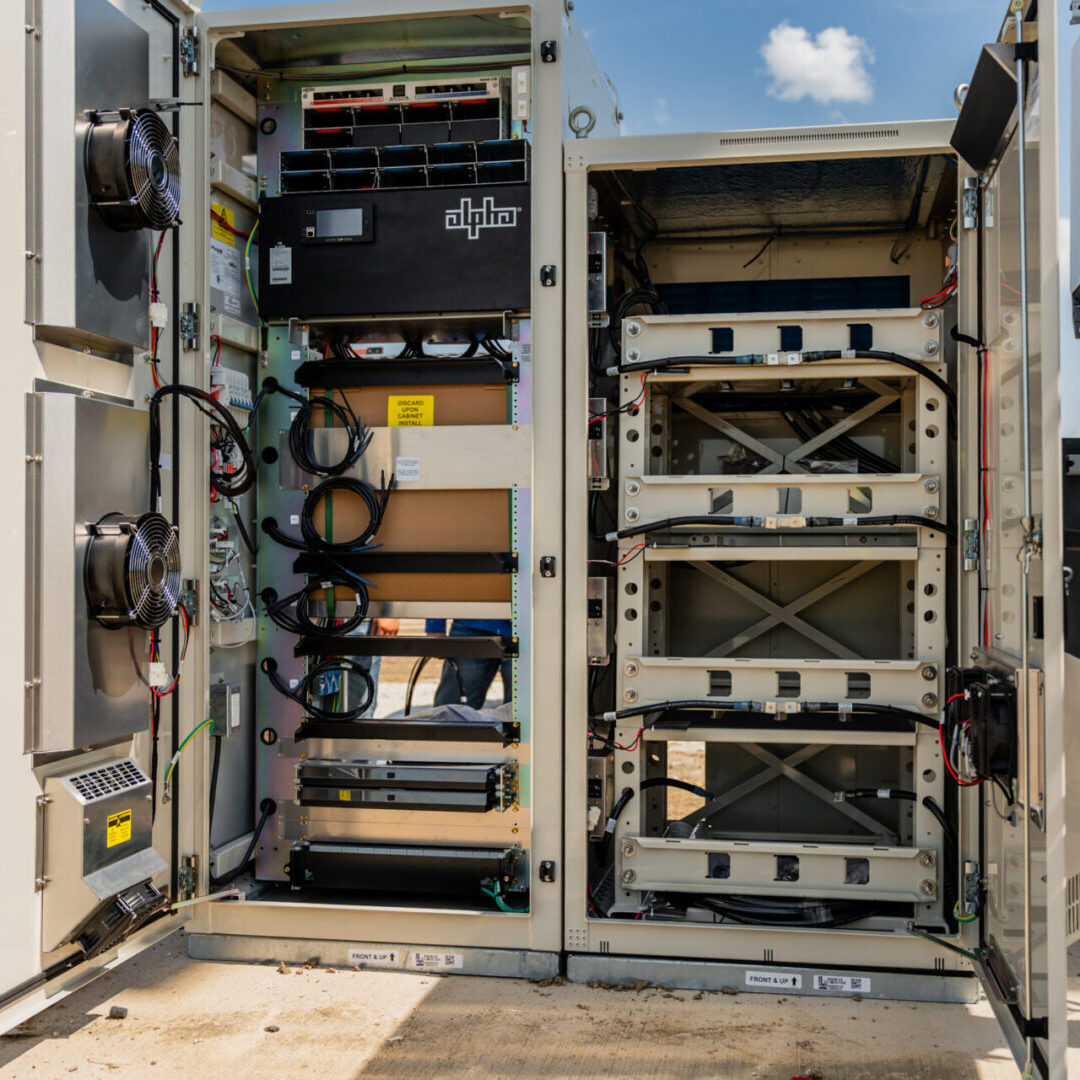 Open server rack with various electronic equipment and cables.